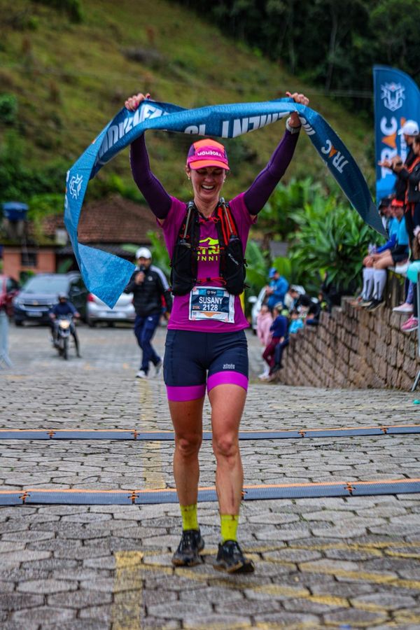 Atleta comemorando ao romper a faixa de chegada